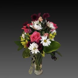 Mixed bouquet of pink roses and white daisies in a clear glass vase