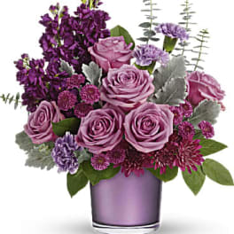 Purple roses and mixed purple flowers in a lavender vase