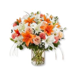 Orange and white floral bouquet in a clear glass vase