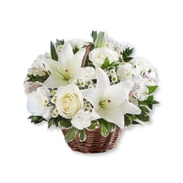 White lilies and roses arranged in a wicker basket