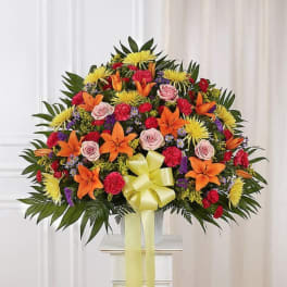 Large mixed floral spray with orange lilies, pink roses, and yellow blooms