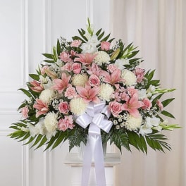 Large pink and white floral spray with a white ribbon bow