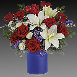 Red roses and white lilies arranged in a blue vase