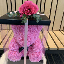 Pink rose teddy bear in a clear gift box with a ribbon