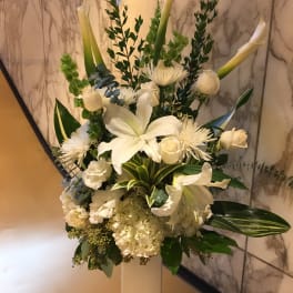 Tall white floral arrangement in a pedestal vase