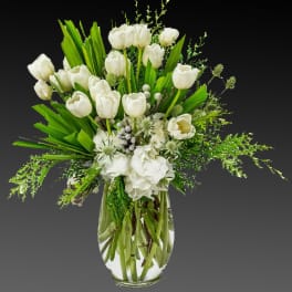 White tulips and hydrangeas in a clear glass vase