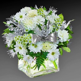 White daisy bouquet in a clear square vase with a silver ribbon