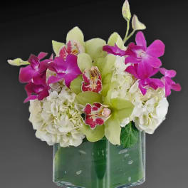Bouquet of white hydrangeas and pink orchids in a glass vase