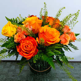 Bouquet of orange and yellow roses in a glass vase