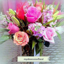 Bouquet of pink and peach roses with lilies in a glass vase