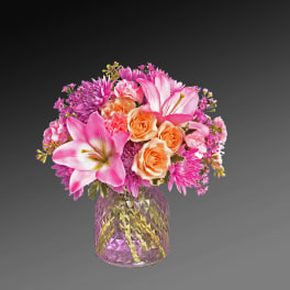 Pink and peach mixed bouquet in a faceted glass vase