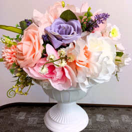 Artificial pastel rose bouquet in a white pedestal vase