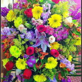 Large mixed bouquet with roses, lilies, and bright daisy-like flowers