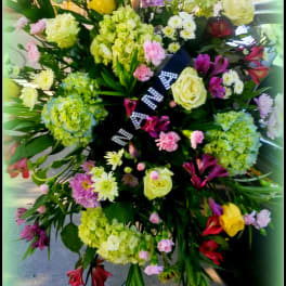 Large standing floral spray with roses, hydrangeas, and mixed blooms