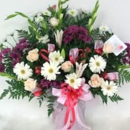 Bouquet of white daisies and pale roses with purple flowers in a vase