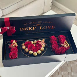 Red roses and chocolates arranged in a black gift box