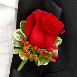 Red rose boutonniere with variegated greenery and red berries on a black suit lapel
