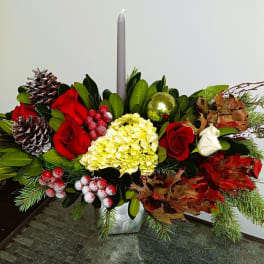 Holiday centerpiece with red and white roses, hydrangea, and a gray candle