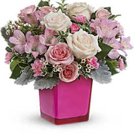Pink and white roses arranged in a bright pink vase