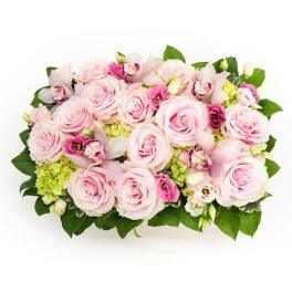 Low rectangular arrangement of pale pink roses, green hydrangeas, and pink blooms in a compact design