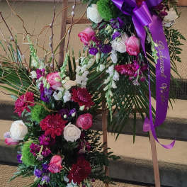 Two floral standing sprays with pink, white, and purple flowers on easels