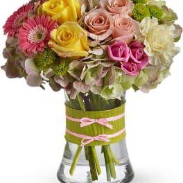 Mixed bouquet of roses and gerbera daisies in a glass vase