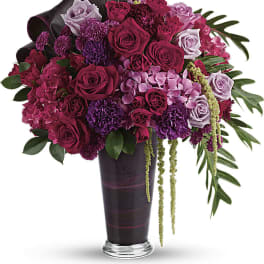 Bouquet of pink and purple roses in a tall dark vase