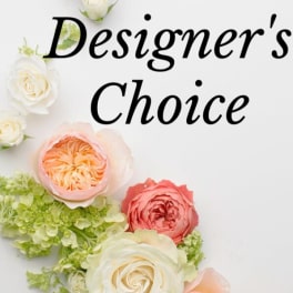 White, peach, and pink roses with green hydrangea accents under the text “Designer’s Choice”.