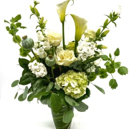 White and pale green floral arrangement in a glass vase