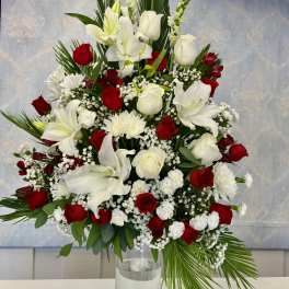 Tall red and white floral arrangement in a clear glass vase