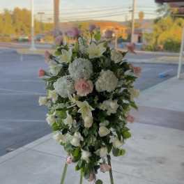 Tall standing floral spray with white and blush flowers on a tripod easel