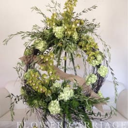 Large circular floral wreath with green orchids and pale green blooms
