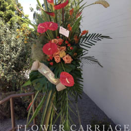Tall tropical standing spray with pink anthuriums and orange roses