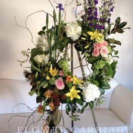 Tall floral standing arrangement with pink roses, yellow lilies, and white hydrangeas