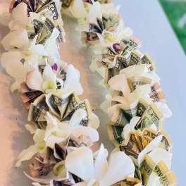 White flower garland with folded dollar bills woven into each bloom