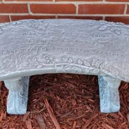 Decorative memorial bench with an engraved quote and floral vine details