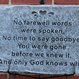 Memorial stone plaque with engraved sympathy verse on a stand