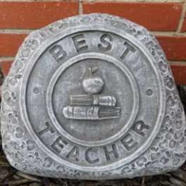 Stone plaque reading "Best Teacher" with an apple and books emblem