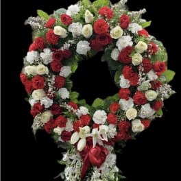 Large red and white floral wreath with a cascading ribbon tail