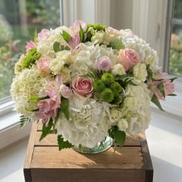 Pink and white rose bouquet with hydrangeas in a glass vase