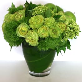Monochromatic green arrangement with roses and apples in a clear glass vase