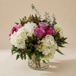 Pink roses and white hydrangeas in a clear glass vase