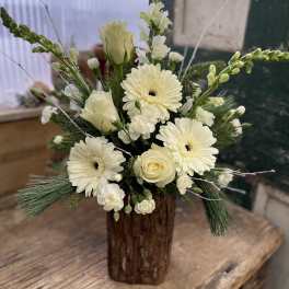 Cream floral arrangement in a rustic wooden vase