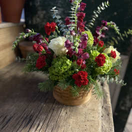 Basket arrangement with red and white flowers and green blooms