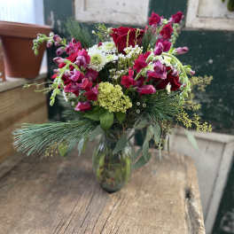Bouquet of red roses and pink snapdragons in a glass vase
