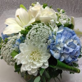 Bouquet of white roses, lilies, and blue hydrangea