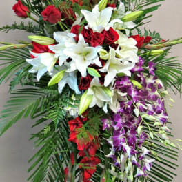 Tall standing floral spray with red roses, white lilies, and purple orchids