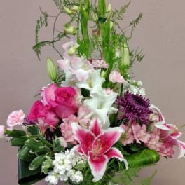 Pink and white mixed flower arrangement in a dark vase
