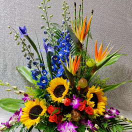 Colorful tropical bouquet with sunflowers, orchids, and blue flowers