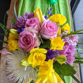 Bouquet of pink roses, yellow daffodils, and purple flowers